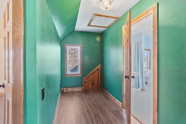 interior space with lofted ceiling, baseboards, and wood finished floors