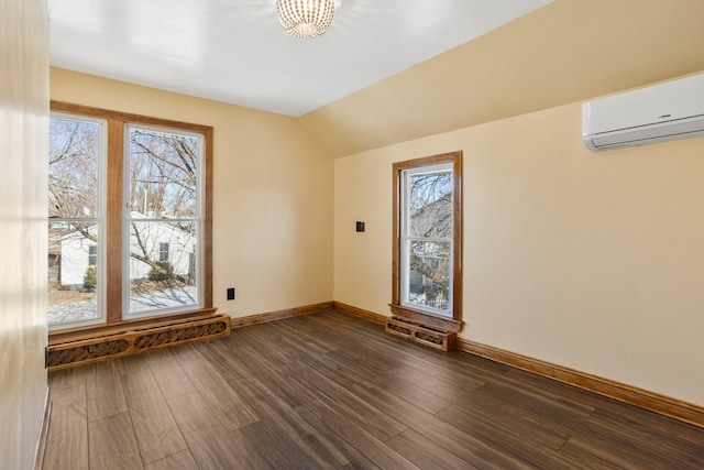 additional living space with dark wood-style flooring, a wall mounted air conditioner, plenty of natural light, and baseboards