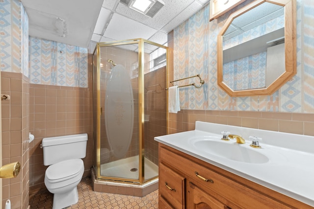 bathroom with vanity, tile walls, an enclosed shower, and toilet