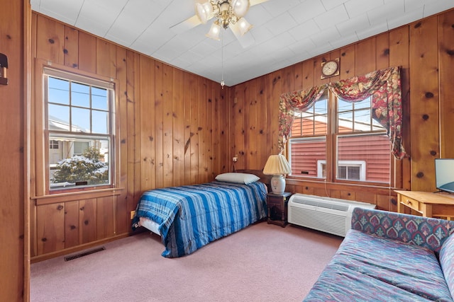 bedroom featuring ceiling fan, carpet floors, a wall mounted air conditioner, and wooden walls