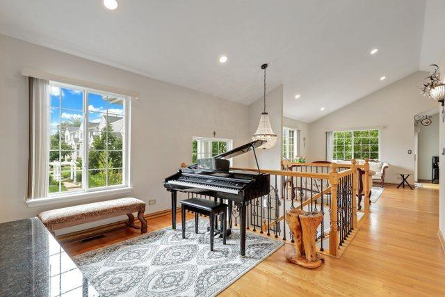 sitting room with wood-type flooring, high vaulted ceiling, and an inviting chandelier