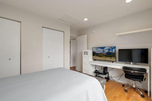 bedroom with two closets and wood-type flooring