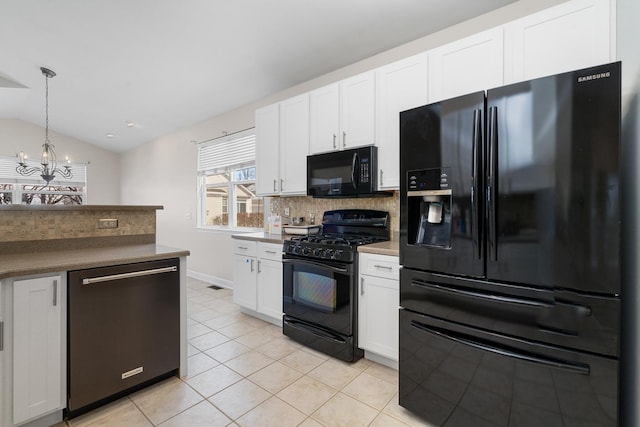 kitchen featuring lofted ceiling, light tile patterned floors, backsplash, white cabinetry, and black appliances