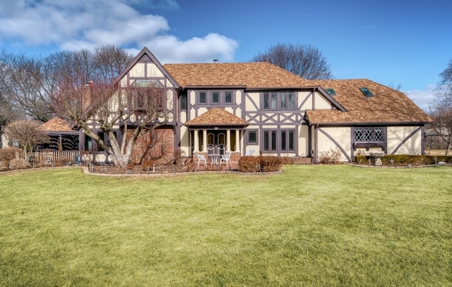 rear view of house with a lawn and stucco siding