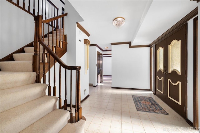 entryway featuring ornamental molding, french doors, baseboards, and stairs