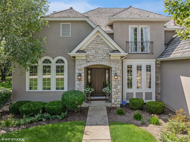 entrance to property with a balcony and stucco siding