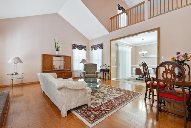 living room featuring high vaulted ceiling, a notable chandelier, and wood-type flooring