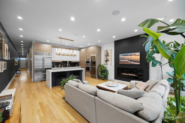 living room featuring a large fireplace and light wood-type flooring