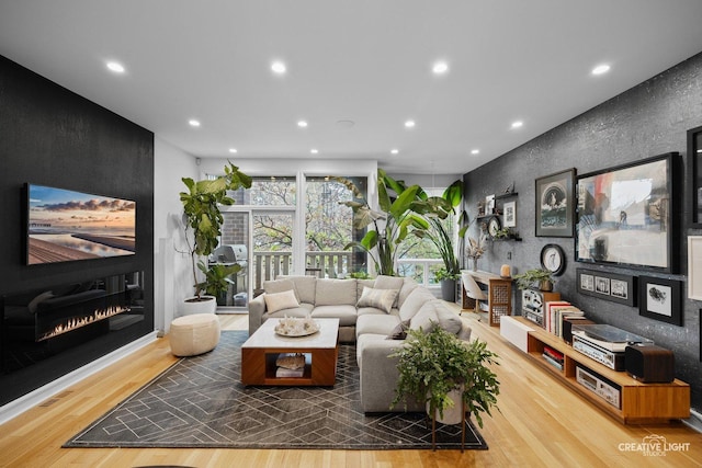 living room featuring hardwood / wood-style flooring and a large fireplace