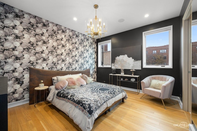 bedroom with light hardwood / wood-style flooring and a notable chandelier