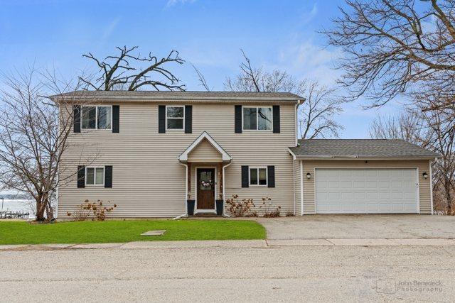 view of front of property with an attached garage, driveway, and a front lawn