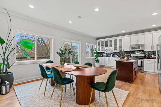 dining area featuring light wood finished floors, ornamental molding, recessed lighting, and baseboards