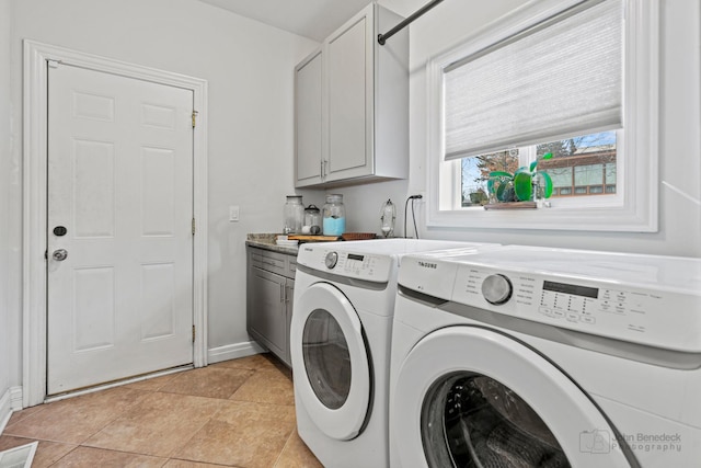 clothes washing area featuring light tile patterned floors, cabinet space, visible vents, separate washer and dryer, and baseboards