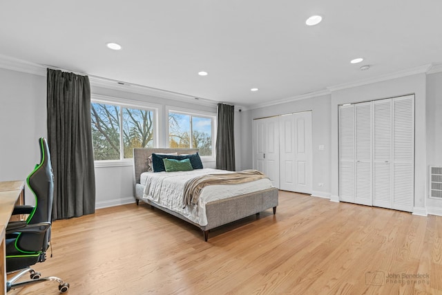 bedroom with visible vents, ornamental molding, light wood-type flooring, two closets, and recessed lighting