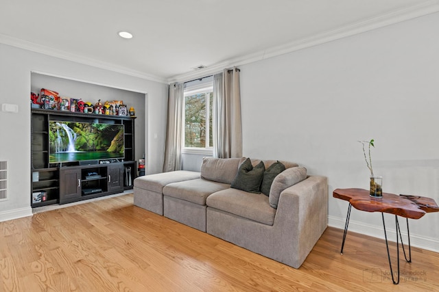 living area featuring visible vents, crown molding, baseboards, and wood finished floors