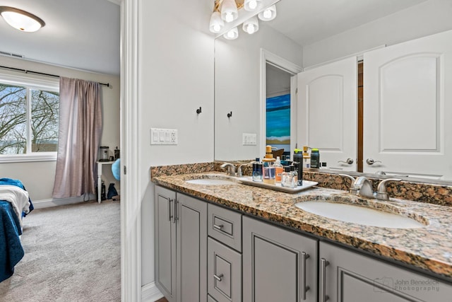 bathroom featuring double vanity, a sink, and ensuite bathroom