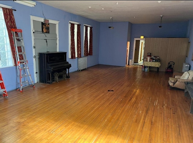 unfurnished living room with hardwood / wood-style flooring and radiator heating unit