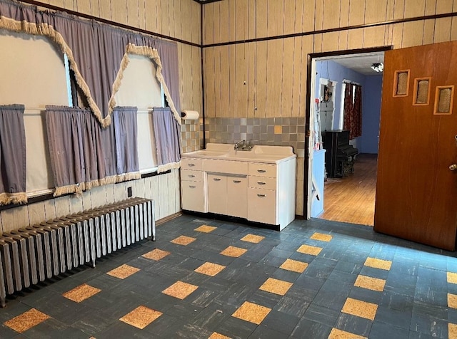 interior space with white cabinetry, radiator, and sink