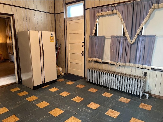 interior space with radiator heating unit and wood walls