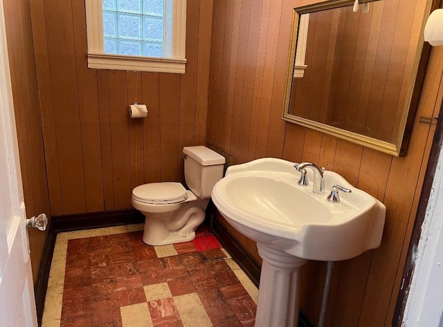 bathroom featuring toilet and wood walls