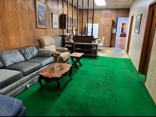 interior space featuring a paneled ceiling and wood walls