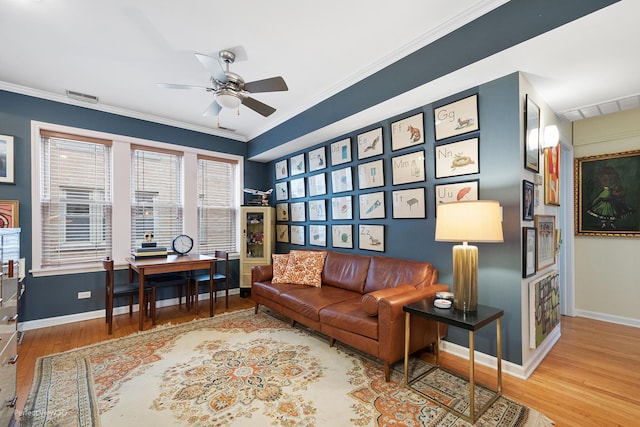 living room featuring hardwood / wood-style floors, crown molding, and ceiling fan