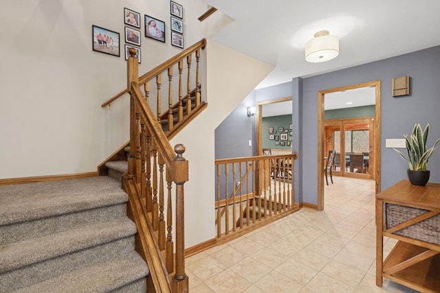 staircase with baseboards and tile patterned flooring