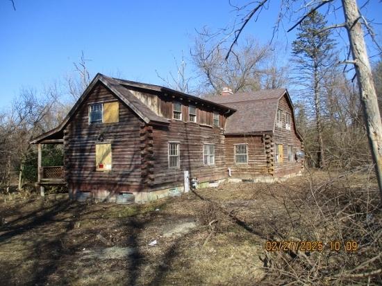 view of side of property featuring log siding and a gambrel roof