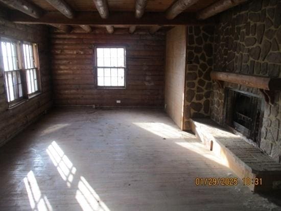 125 N Anderson Rd, New Lenox, IL 60451 - unfurnished living room featuring a healthy amount of sunlight, a fireplace, beamed ceiling, and wood finished floors