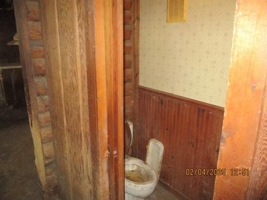 125 N Anderson Rd, New Lenox, IL 60451 - bathroom with toilet, a wainscoted wall, wood walls, visible vents, and wallpapered walls