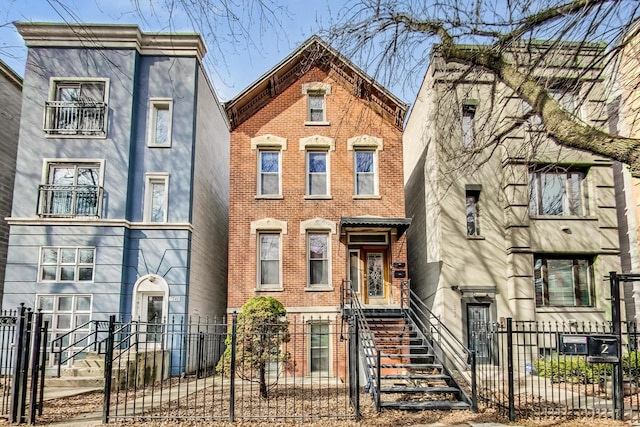 view of front of home featuring brick siding, a gate, and a fenced front yard