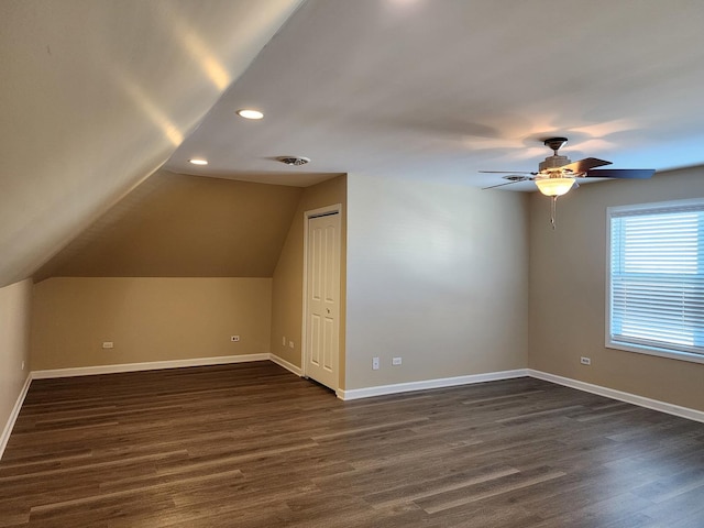 bonus room with dark wood finished floors, visible vents, and baseboards