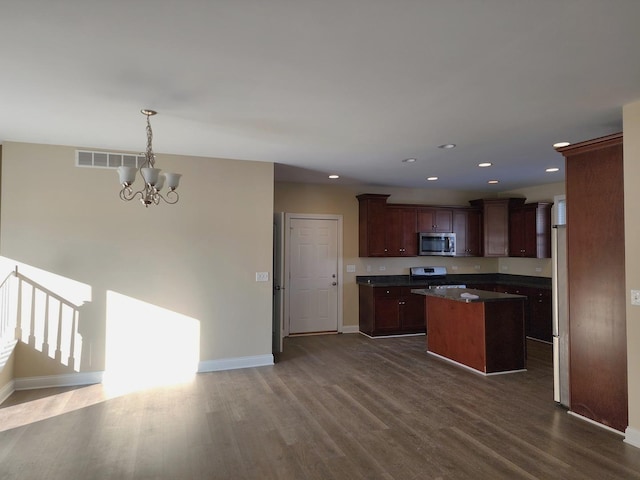 kitchen with stainless steel appliances, visible vents, a center island, dark countertops, and pendant lighting