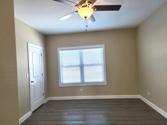 unfurnished room featuring a ceiling fan, dark wood-style flooring, and baseboards