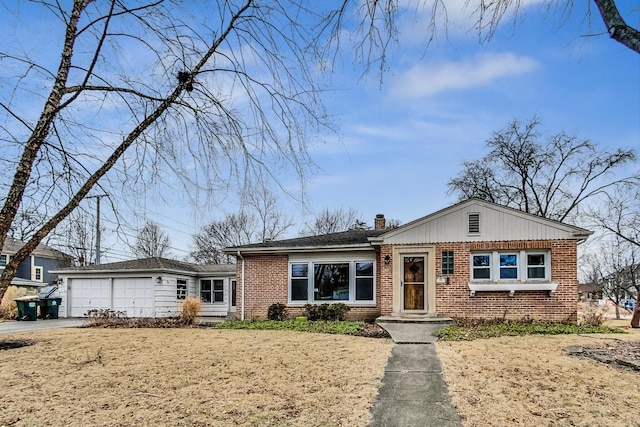 view of front facade with a garage, driveway, a chimney, and brick siding