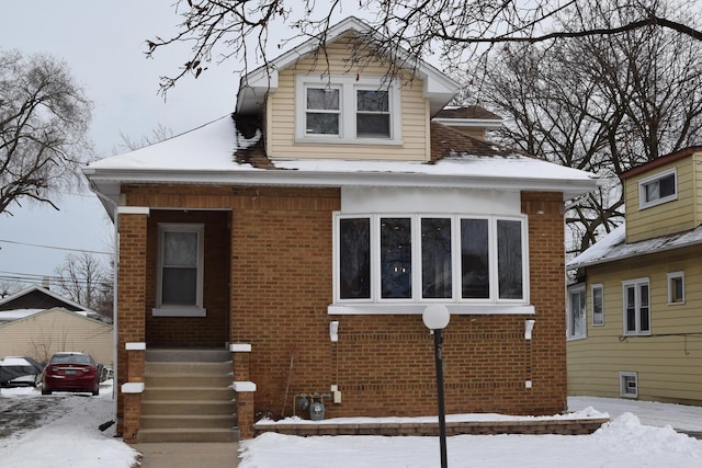 bungalow-style house with entry steps and brick siding