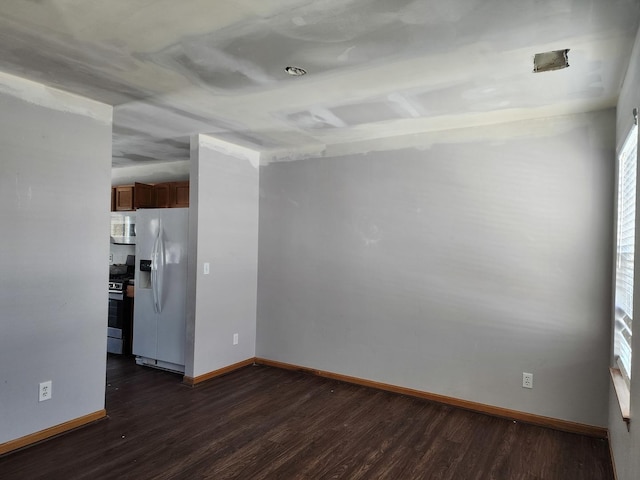 unfurnished room featuring baseboards and dark wood-type flooring