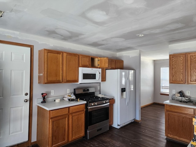 kitchen featuring brown cabinets, white appliances, and light countertops