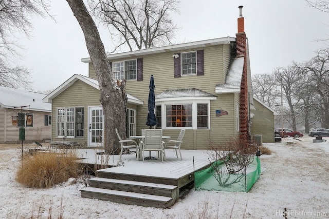 snow covered property with a deck