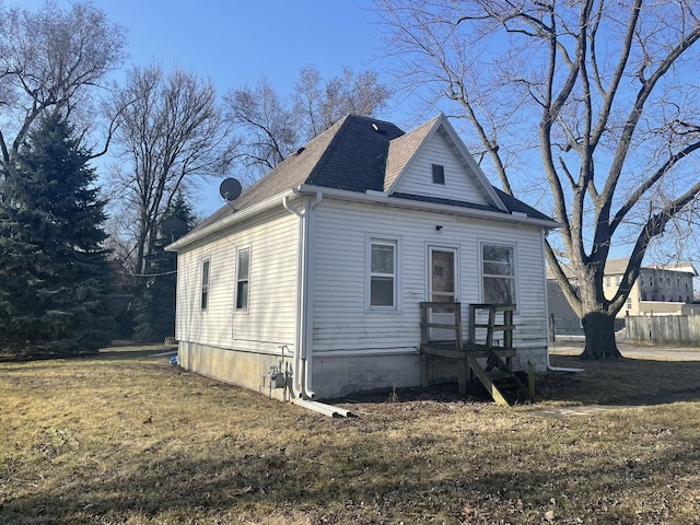 view of front of house with a front yard and roof with shingles