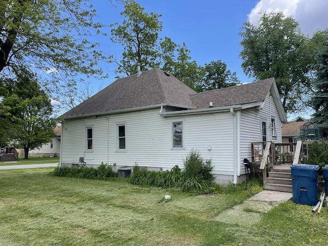 322 W Grant St, Pontiac, IL 61764 - view of property exterior featuring roof with shingles, a deck, and a lawn