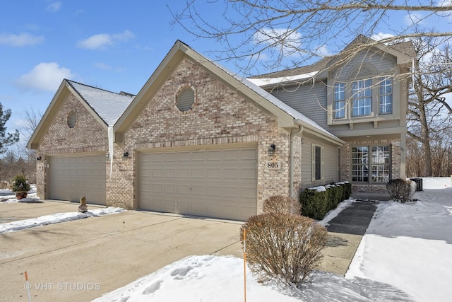 traditional home with a garage, driveway, and brick siding