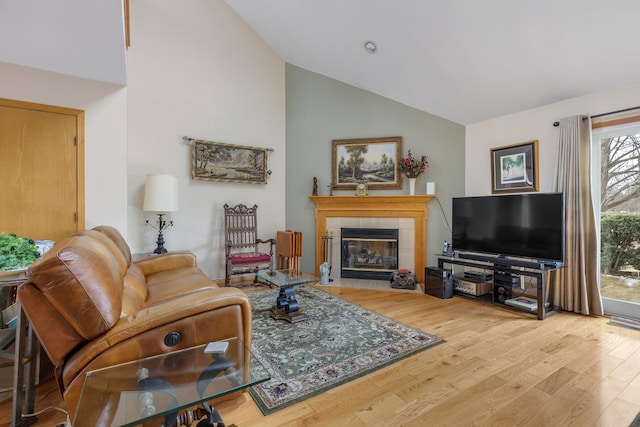 living room featuring hardwood / wood-style flooring, a fireplace, and high vaulted ceiling