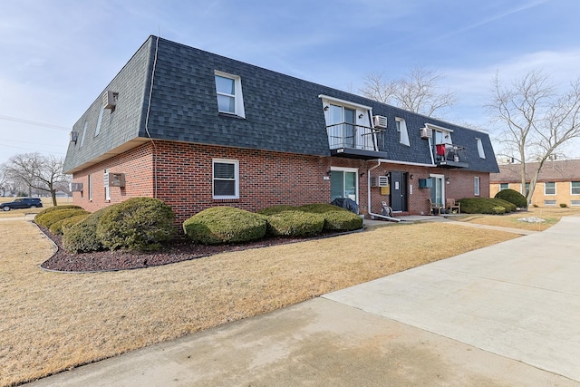 view of front of home with a front lawn and a balcony