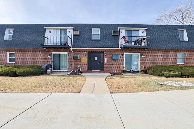 multi unit property featuring a front lawn and a balcony