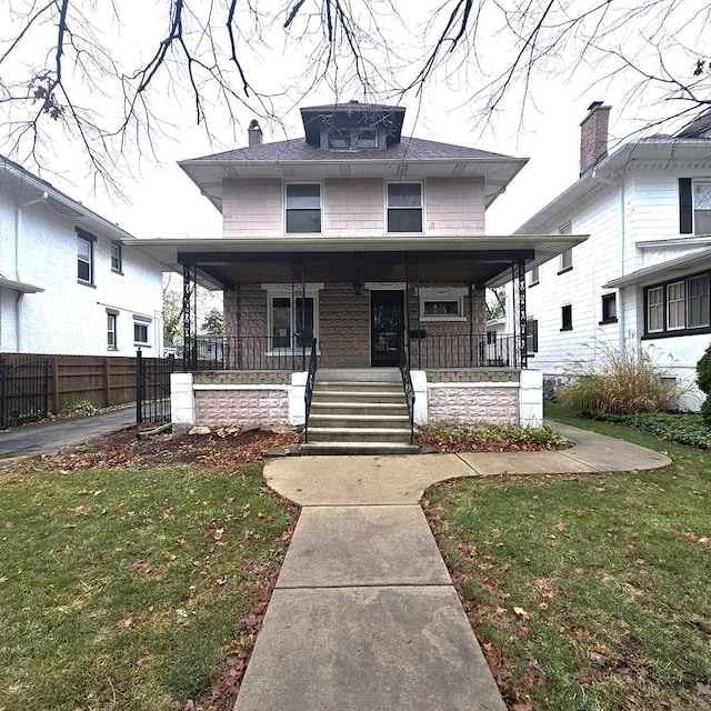 view of front of home with a porch and a front lawn