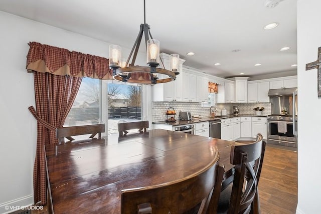 dining space featuring dark hardwood / wood-style floors, sink, and a notable chandelier