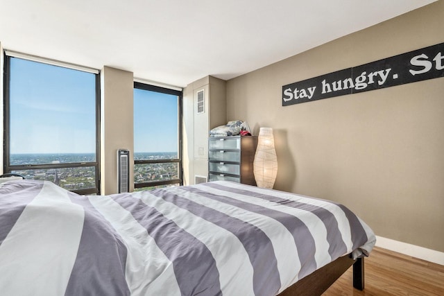 bedroom featuring hardwood / wood-style flooring and floor to ceiling windows