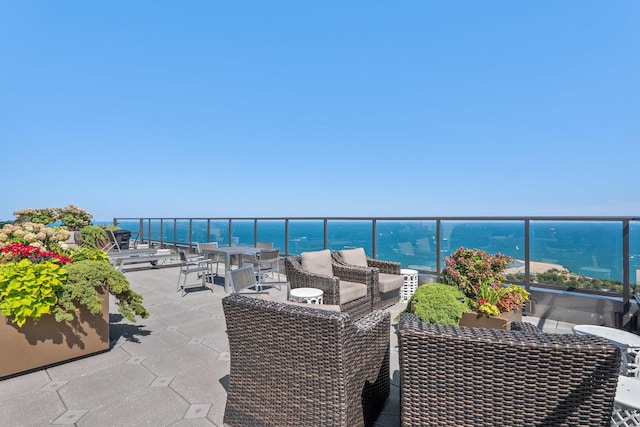 view of patio featuring a balcony and a water view