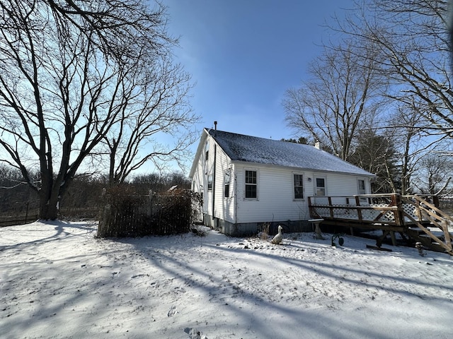 snow covered house featuring a deck